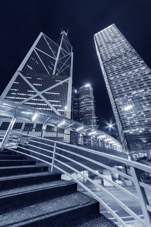 escalera de pasarela peatonal y rascacielos en el centro de la ciudad de Hong Kong por la noche
