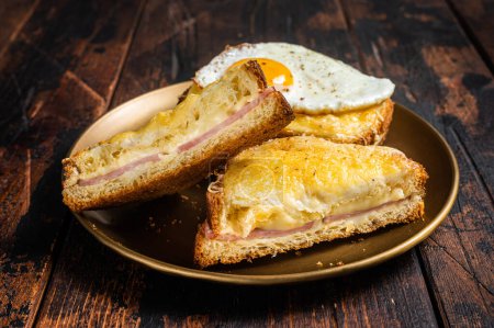 Photo for French toasts Croque monsieur and croque madame, grilled sandwiches on brioch bread with sliced ham, melted emmental cheese and egg. Wooden background. Top view. - Royalty Free Image