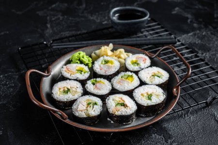 Téléchargez les photos : Kimbap gimbap filled with vegetables, egg, eanchovy and crab, Korean rice roll. Black background. Top view. - en image libre de droit