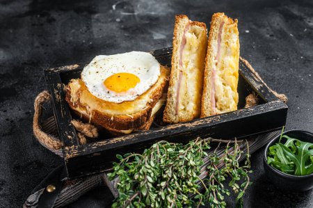 Photo for French toasts croque monsieur and croque madame with sliced ham, melted emmental cheese and egg. Black background. Top view. - Royalty Free Image