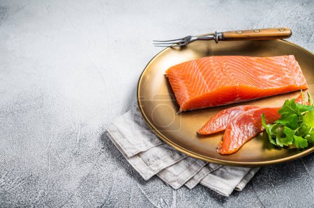 Salted salmon fillet with thyme in a steel plate. White background. Top view. Copy space.