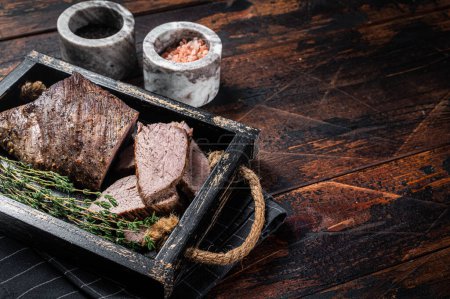 Téléchargez les photos : Grillé Tri Tip steak, surlonge de bœuf dans un plateau avec des herbes. Fond en bois. Vue de dessus. Espace de copie. - en image libre de droit