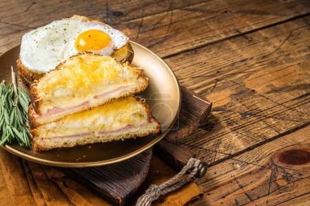 Photo for Croque monsieur and croque madame sandwiches with sliced ham, melted emmental cheese and egg, French toasts. Wooden background. Top view. Copy space. - Royalty Free Image