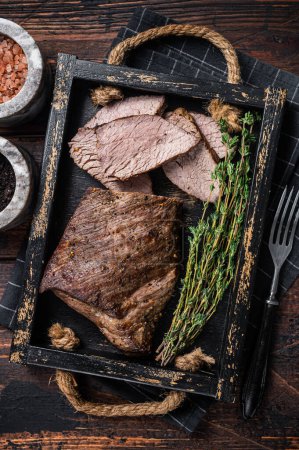 Téléchargez les photos : Grillé Tri Tip steak, surlonge de bœuf dans un plateau avec des herbes. Fond en bois. Vue du dessus. - en image libre de droit