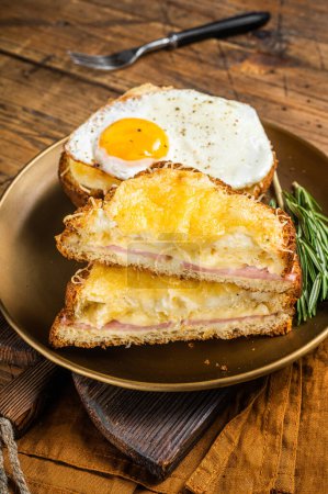 Photo for Croque monsieur and croque madame sandwiches with sliced ham, melted emmental cheese and egg, French toasts. Wooden background. Top view. - Royalty Free Image