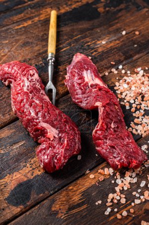Téléchargez les photos : Jupe crue non cuite steak Machete sur fourchette à viande. Fond en bois. Vue du dessus. - en image libre de droit