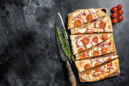 Foto de Homemade Flammkuchen or tarte flambee with cream cheese, bacon, tomato and onions. Black background. Top view. Copy space. - Imagen libre de derechos