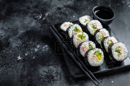Téléchargez les photos : Korean rice roll Kimbap or gimbap, Korean sushi. Black background. Top view. Copy space. - en image libre de droit