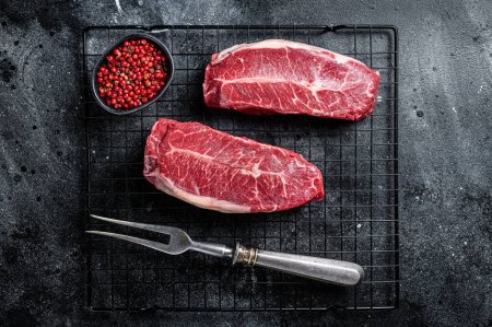 Raw top blade cut organic beef meat. Black background. Top View.