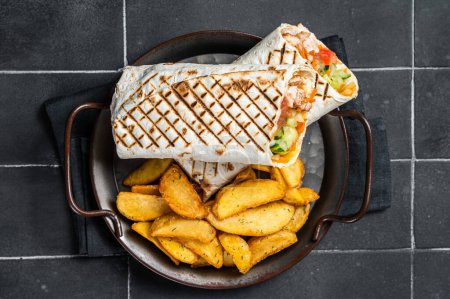 Téléchargez les photos : Shawarma Shaurma kebab with meat, vegetable salad and french fries. Black background. Top view. - en image libre de droit