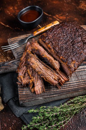 Foto de Traditional smoked barbecue wagyu beef brisket on wooden board. Dark background. Top view. - Imagen libre de derechos