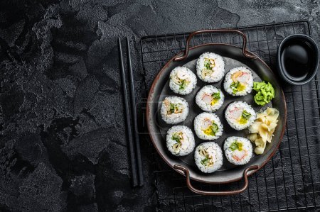 Kimbap gimbap filled with vegetables, egg, eanchovy and crab, Korean rice roll. Black background. Top view. Copy space.