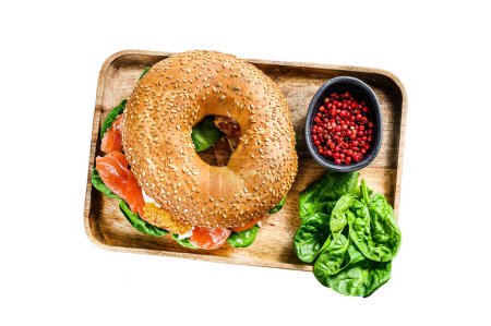 Healthy freshly baked bagel filled with smoked salmon, spinach and egg. Isolated on white background. Top view