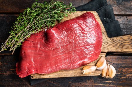 Alternative flank beef steak, raw meat. Wooden background. Top view.