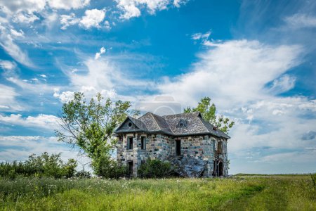Foto de Una casa de piedra abandonada rodeada de árboles en las praderas de Saskatchewan en las afueras de Abernethy, SK - Imagen libre de derechos