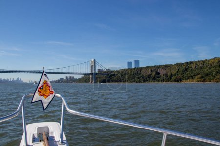 Photo for Fort Lee, NJ, United States - October 5, 2022:  AGLCA penant on the bow of a boat heading under the George Washington Bridge to New York Harbour on the Hudson River - Royalty Free Image