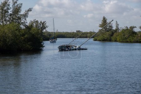 Photo for Sailboat sunk in an anchorage at Vero Beach in Florida. Many vessels were damaged in the area during hurricane Nicole. - Royalty Free Image