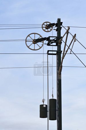 Photo for Mechanical stress compensation systems in structures, counterweights, cable, pulleys and metal gears of catenary or overhead line in train - Royalty Free Image