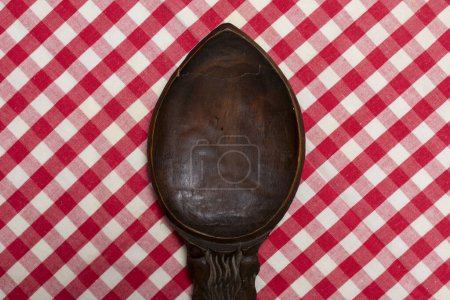 Foto de Cubertería de madera sobre un mantel de cocina a cuadros rojo y blanco - Imagen libre de derechos