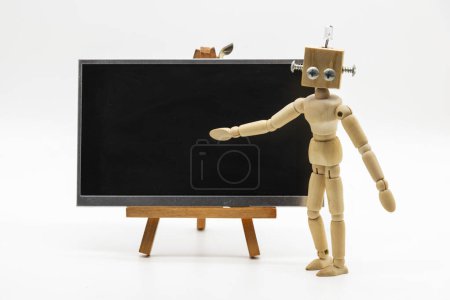 Téléchargez les photos : Petit robot mannequin original, fabriqué avec bois et vis, devant un tableau noir, isolé sur blanc - en image libre de droit