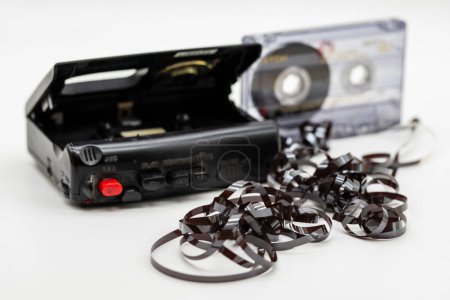 Enchevêtrement de cassettes audio magnétiques. Vieille cassette audio déroulée sur fond blanc