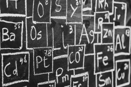 Periodic table of chemistry elements handwritten with chalk on blackboard