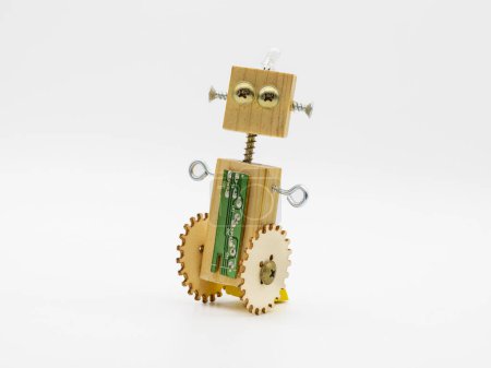 Foto de Robot pequeño hecho con madera y tornillos, con brazos de concha, aislado en blanco - Imagen libre de derechos