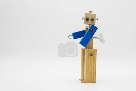 Foto de Pequeño robot hecho con madera y tornillos, con llave enrollable, aislado en blanco - Imagen libre de derechos