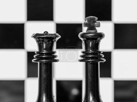 Die Figuren des Königs und der Königin auf einem Schachbrett, schwarz-weiß