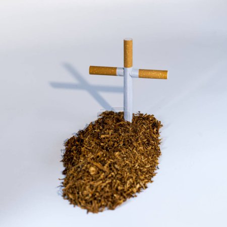 Tumba simbólica de tabaco y cigarrillos de un fumador, aislado en blanco