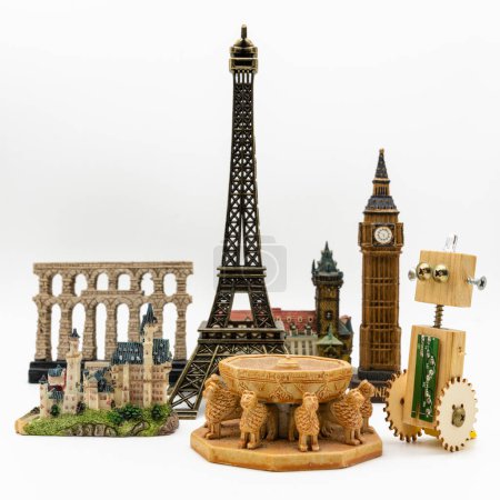 Holzroboter neben mehreren Weltdenkmälern wie dem Eiffelturm, Patio de los Leones de la Alhambra oder Big Ben