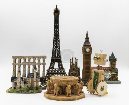 Holzroboter neben mehreren Weltdenkmälern wie dem Eiffelturm, Patio de los Leones de la Alhambra oder Big Ben