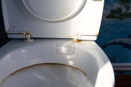 Old and dirty toilet seats, yellow stains, poor condition..