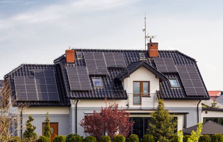 Dach eines privaten Hauses in Europa mit Sonnenkollektoren. Immobilien mit Öko-Sonnenkollektoren aus erneuerbaren Energien.