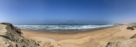 Téléchargez les photos : Maroc, Afrique : vue panoramique sur l'océan Atlantique par une chaude journée avec vagues, sable jaune et rochers le long de la route d'Essaouira - en image libre de droit