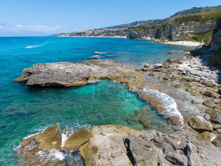 Foto de Vista aérea de la playa Petri i Mulinu y Cueva del Esqueleto, Tropea, Calabria, Italia. Promontorio con vistas al mar, vista panorámica. Mar transparente. Tropea en el fondo - Imagen libre de derechos