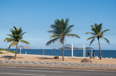 Téléchargez les photos : Rio de Janeiro, Brésil, 06-07-2023 : vue sur la plage d'Ipanema, l'une des plages les plus célèbres du monde, avec le trottoir graphique emblématique le long de l'Avenida Atlantica (Atlantic Avenue), le sable et les palmiers - en image libre de droit