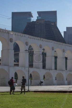 Foto de Río de Janeiro, Brasil, 06-07-2023: personas frente al Acueducto Carioca, conocido como Arcos da Lapa, ejemplo de arquitectura colonial, con la Catedral Metropolitana de San Sebastián al fondo - Imagen libre de derechos