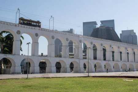 Foto de Río de Janeiro, 06-07-2023: el Acueducto Carioca, conocido como Arcos da Lapa, ejemplo de arquitectura colonial, con el famoso teleférico bonde, tranvía eléctrico en su camino entre Centro y Santa Teresa - Imagen libre de derechos