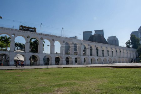 Foto de Río de Janeiro, 06-07-2023: el Acueducto Carioca, conocido como Arcos da Lapa, ejemplo de arquitectura colonial, con el famoso teleférico bonde, tranvía eléctrico en su camino entre Centro y Santa Teresa - Imagen libre de derechos