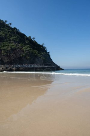 Téléchargez les photos : Rio de Janeiro, Brésil, Amérique du Sud, 06-07-2023 : Pedra do Leme (Leme Rock), une colline rocheuse pleine de végétation, avec le sable et l'eau cristalline sur la plage de Leme, à côté de la plage de Copacababana - en image libre de droit