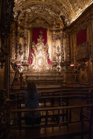 Foto de Río de Janeiro, Brasil, 06-07-2023: mujer rezando en la Capilla del Santísimo Sacramento en la Abadía de Nuestra Señora de Montserrat (Monasterio de San Benito), abadía benedictina fundada por los monjes en 1590 - Imagen libre de derechos