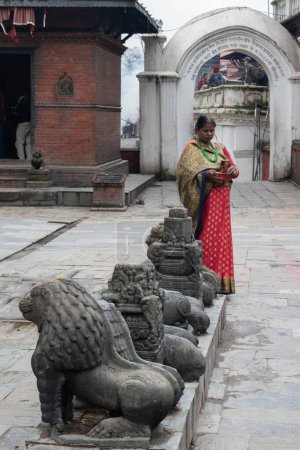 Photo for Kathmandu, Nepal, 10-03-2023: a hindu woman taking pictures inside the complex of Pashupatinath Temple, the famous Hindu temple dedicated to Shiva along the banks of the sacred Bagmati river - Royalty Free Image