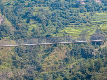 Luftaufnahme einer tibetischen Hängebrücke in Nepal ist ein primitiver Brückentyp, bei dem das Deck auf zwei parallel tragenden Seilen liegt, die an beiden Enden verankert sind. Wilde Natur