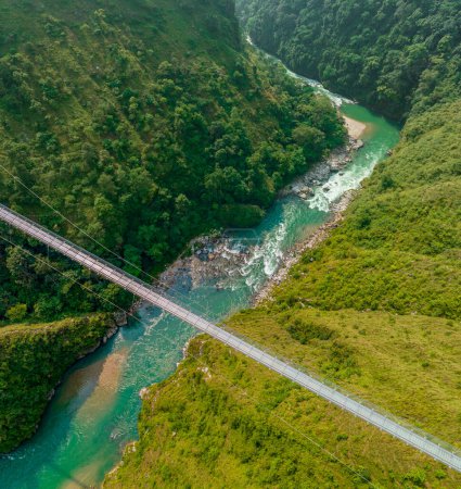 Vista aérea de un puente colgante tibetano en Nepal es un tipo primitivo de puente en el que la cubierta se encuentra en dos cables paralelos de carga que están anclados en cada extremo. Naturaleza salvaje