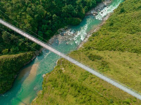 Widok z lotu ptaka na tybetański most wiszący w Nepalu jest prymitywnym rodzajem mostu, w którym pokład leży na dwóch równoległych kablach nośnych zakotwiczonych na obu końcach. Dzika przyroda