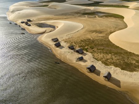 Aerial view of Parque da Dunas - Ilha das Canarias, Brazil. Huts on the Delta do Parnaba and Delta das Americas. Lush nature and sand dunes. Boats on the river bank