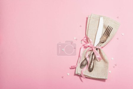 Photo for Romantic table setting in pink tones. Vintage cutlery, fresh flowers, linen napkin. Festive concept background, flat lay, hard light, dark shadow, top view - Royalty Free Image