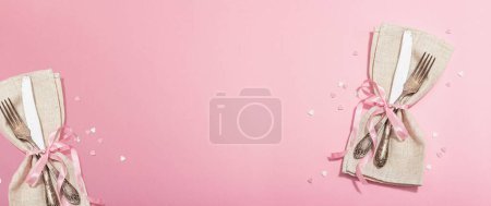 Foto de Mesa romántica en tonos rosados. Cubertería vintage, flores frescas, servilleta de lino. Fondo de concepto festivo, plano, luz dura, sombra oscura, formato de banner - Imagen libre de derechos