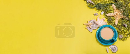 Photo for A cup of coffee in a marine style. Starfish, sea shells, palm leaves. Hard light, dark shadow, bright yellow background, banner format - Royalty Free Image